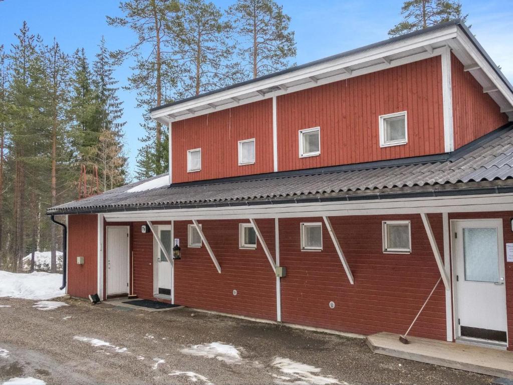 ein rotes Gebäude mit weißen Türen und Schnee auf dem Boden in der Unterkunft Holiday Home Lomakatti 7 b by Interhome in Vuokatti