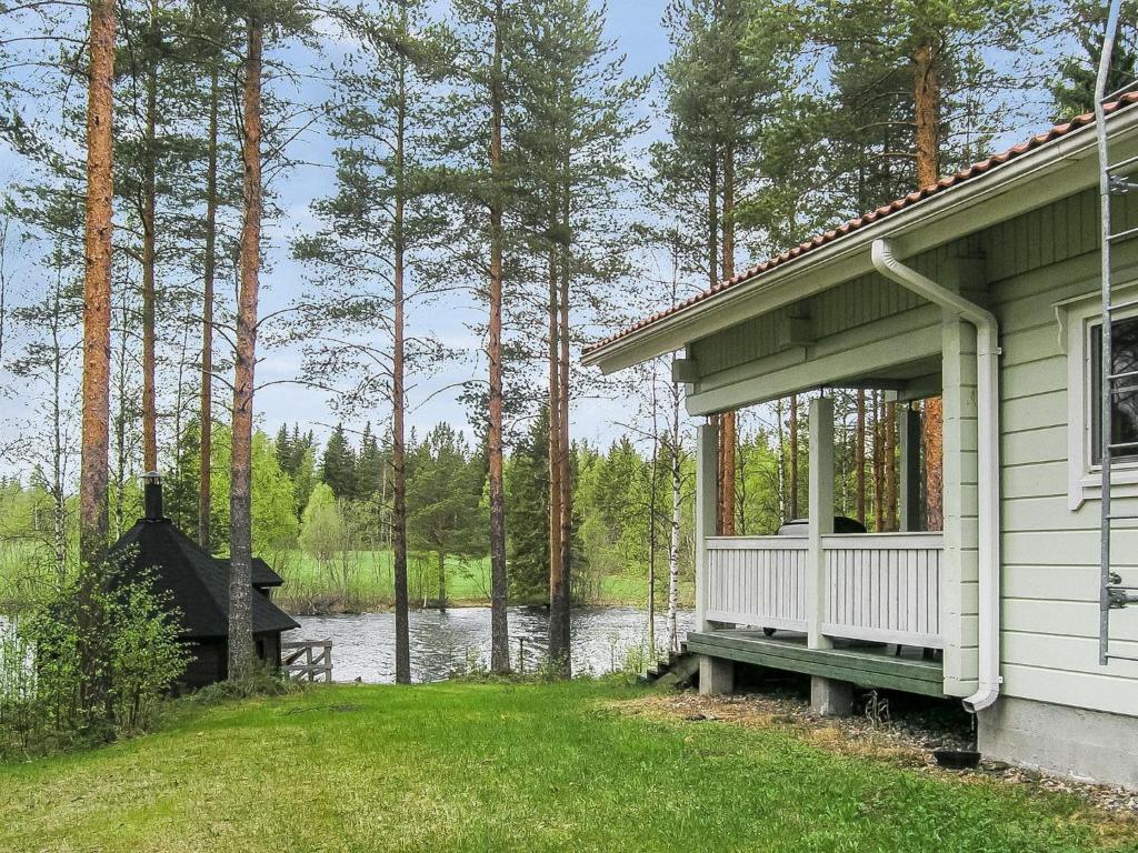 a house with a porch next to a body of water at Holiday Home Yläneuvola silta by Interhome in Neuvola