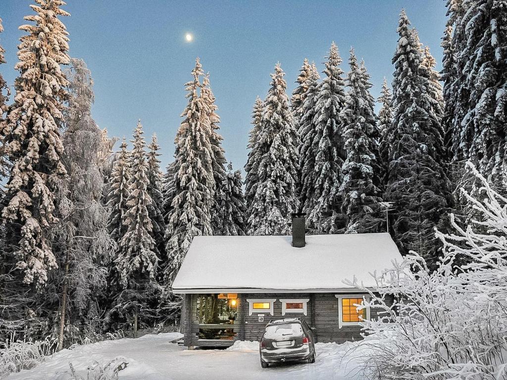 a cabin in the snow with a car parked in front at Holiday Home Mustikka by Interhome in Hauho