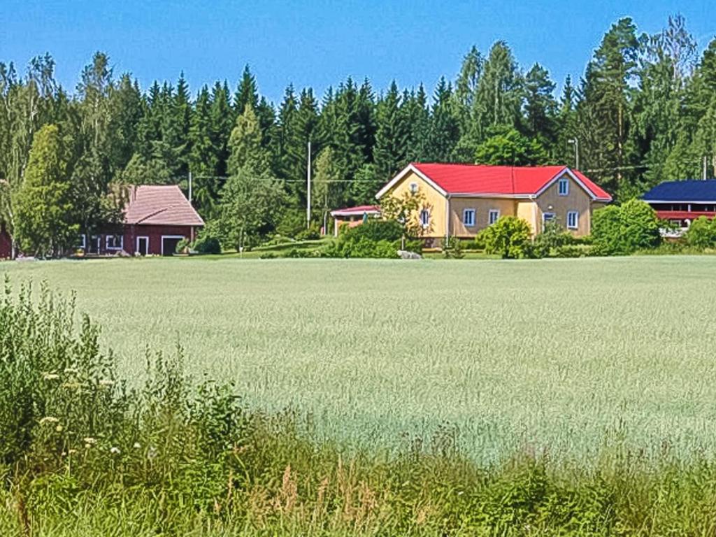 ein großes Grasfeld mit Häusern und Bäumen in der Unterkunft Holiday Home Virrin tila by Interhome in Innala
