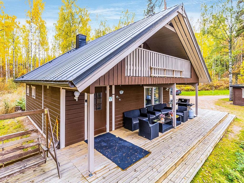 a wooden deck with a house with a roof at Holiday Home Ranta 3 by Interhome in Vääksy