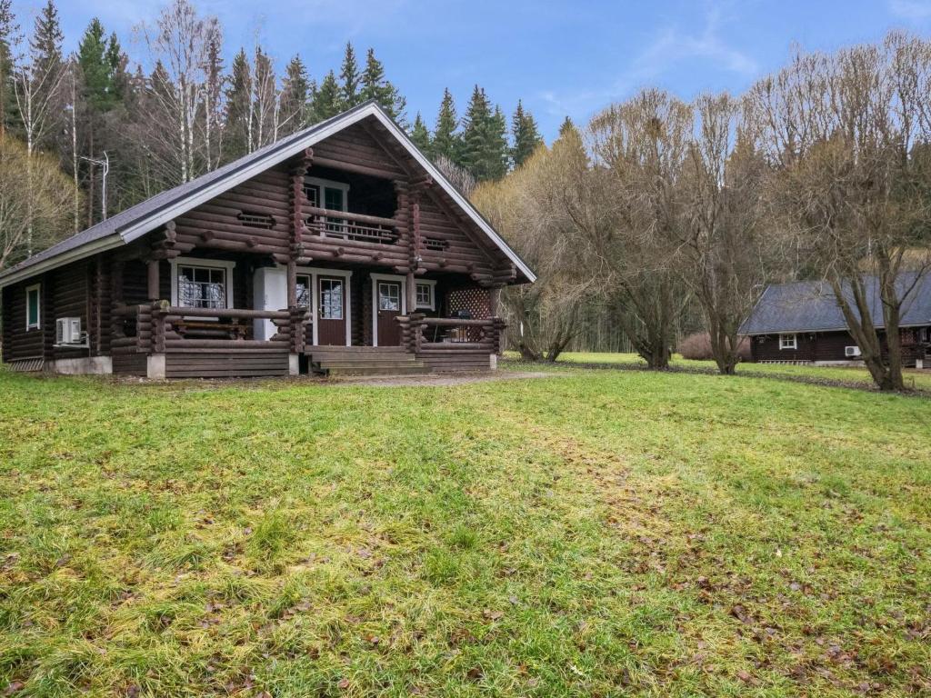 a log cabin with a grass field in front of it at Holiday Home Karhunluola by Interhome in Hauho