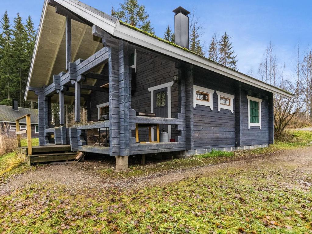 a log cabin with a porch on a field at Holiday Home Puolukka by Interhome in Hauho