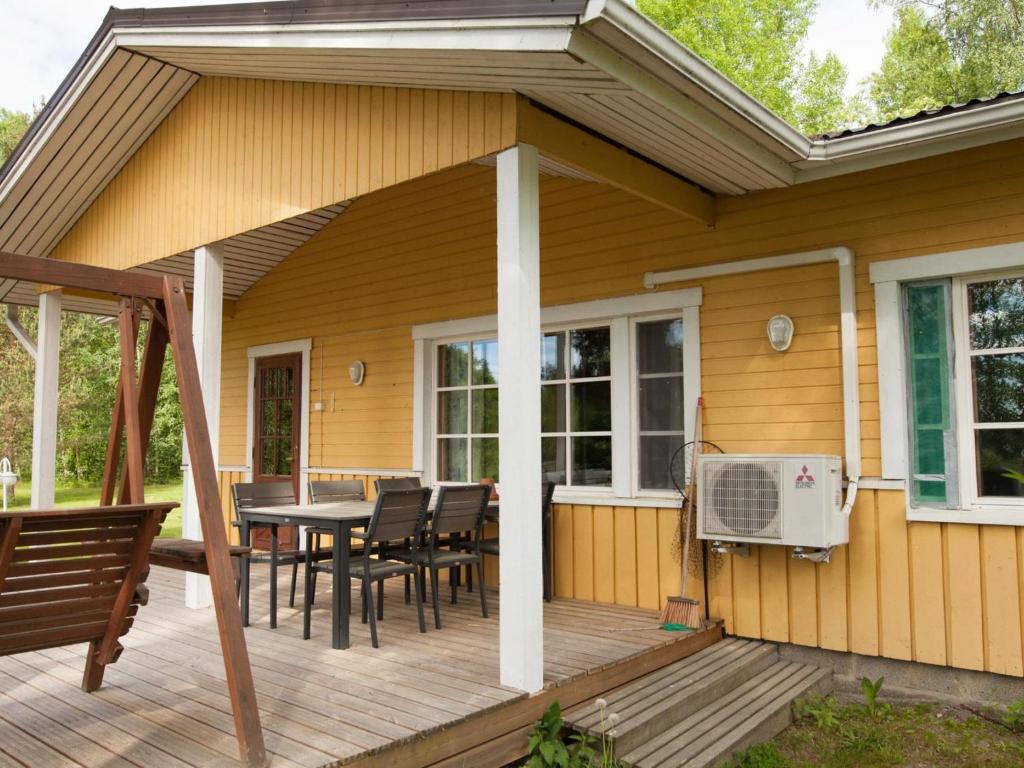 una terraza de madera con mesa y sillas en una casa en Holiday Home Keltalilja by Interhome en Sipsiö