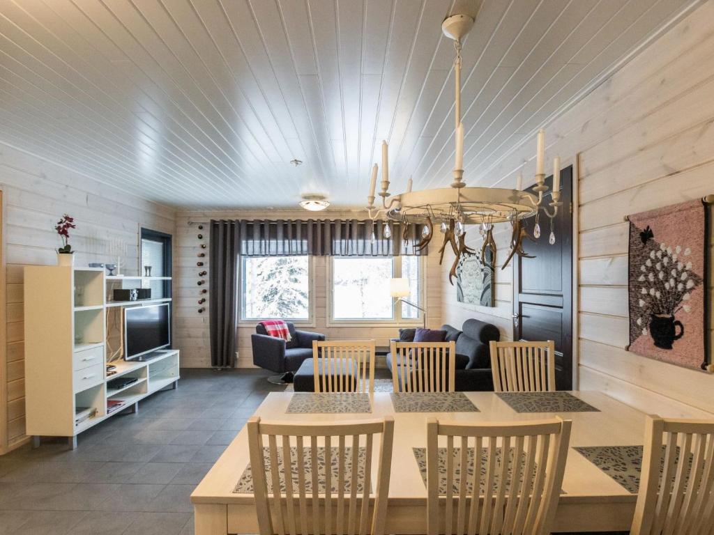 a dining room and living room with a table and chairs at Holiday Home Hil-lak-ka ii as 5 by Interhome in Äkäslompolo