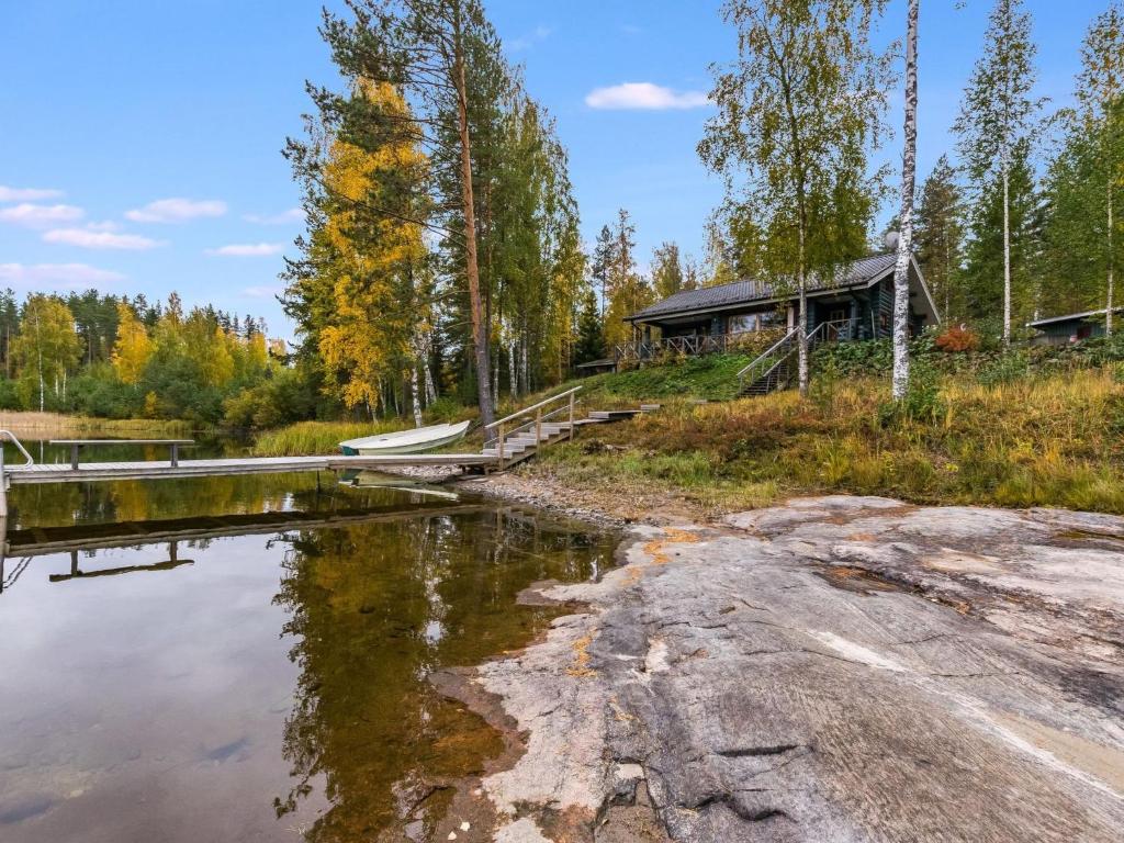 a cabin in the woods next to a body of water at Holiday Home Koivuranta by Interhome in Kokkosenlahti