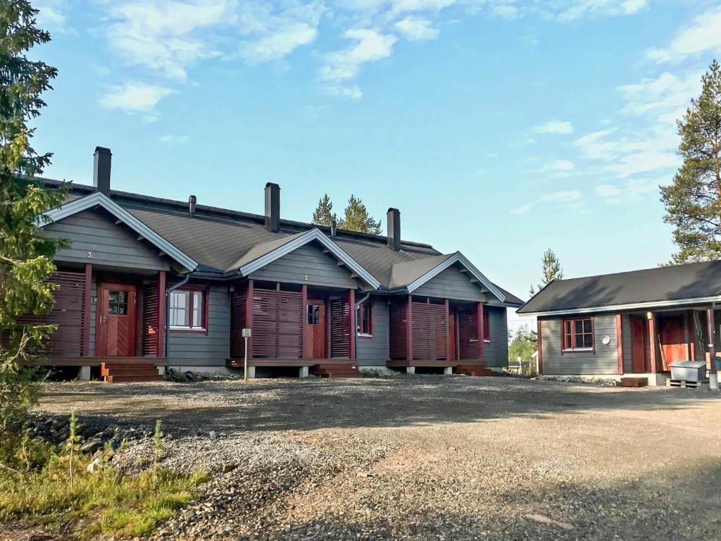 a row of wooden cabins in front of a house at Holiday Home Villa hytönen 1 by Interhome in Äkäslompolo