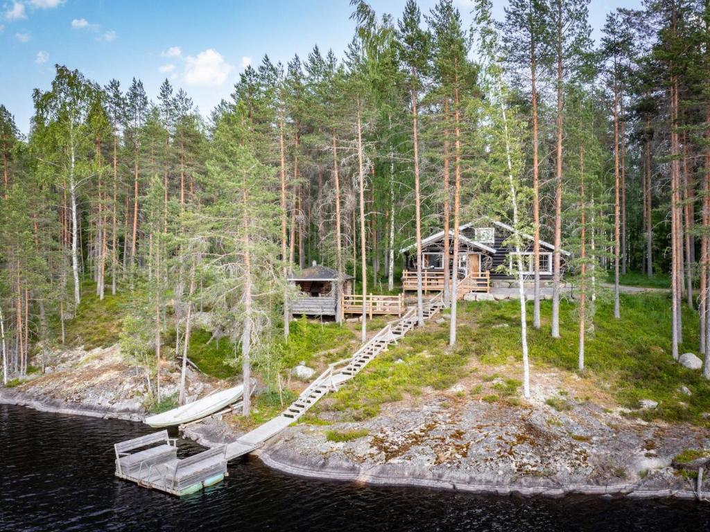 un'isola in mezzo all'acqua con una baita di tronchi di Holiday Home Kalliomökki by Interhome a Huuhanaho