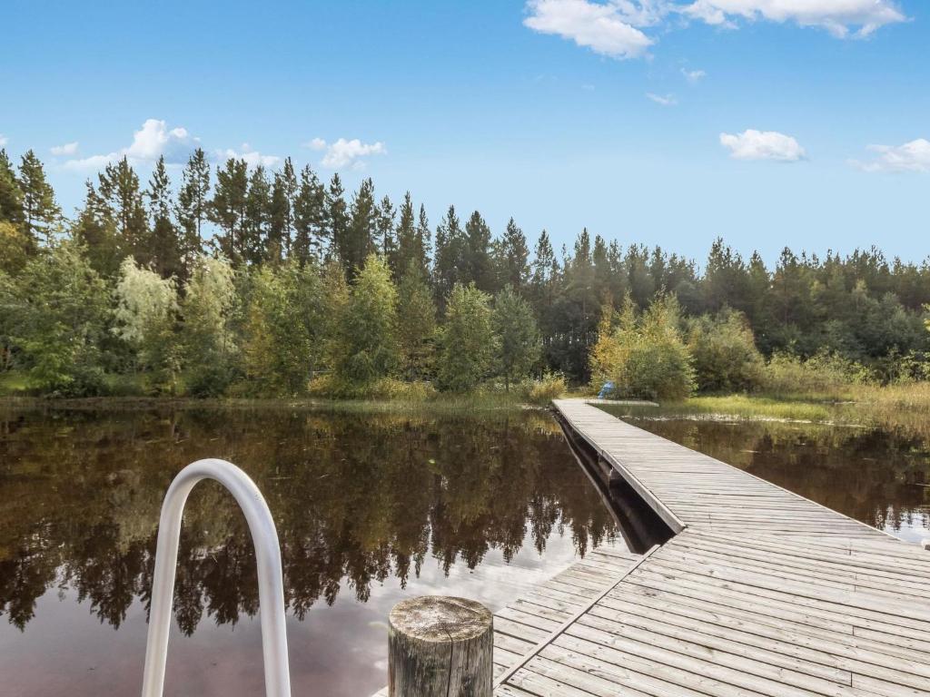 a boardwalk over a lake with trees in the background at Holiday Home Rajala by Interhome in Neuvosenniemi