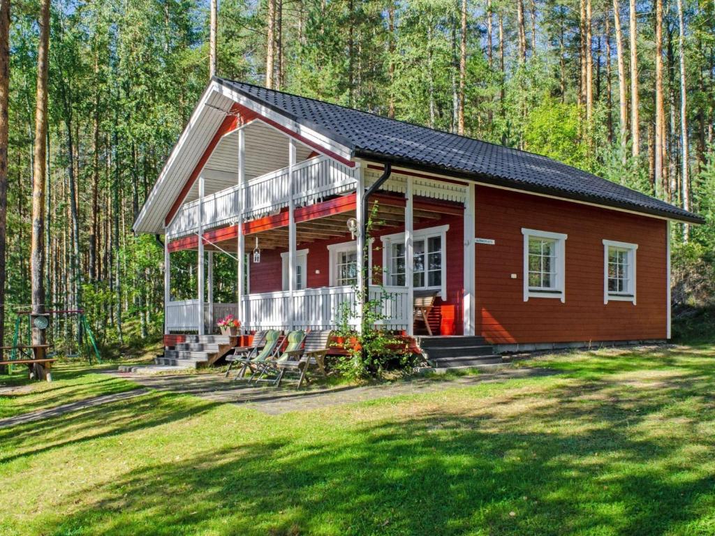 a red cabin in the middle of a forest at Holiday Home Aurinkoranta by Interhome in Hattusaari