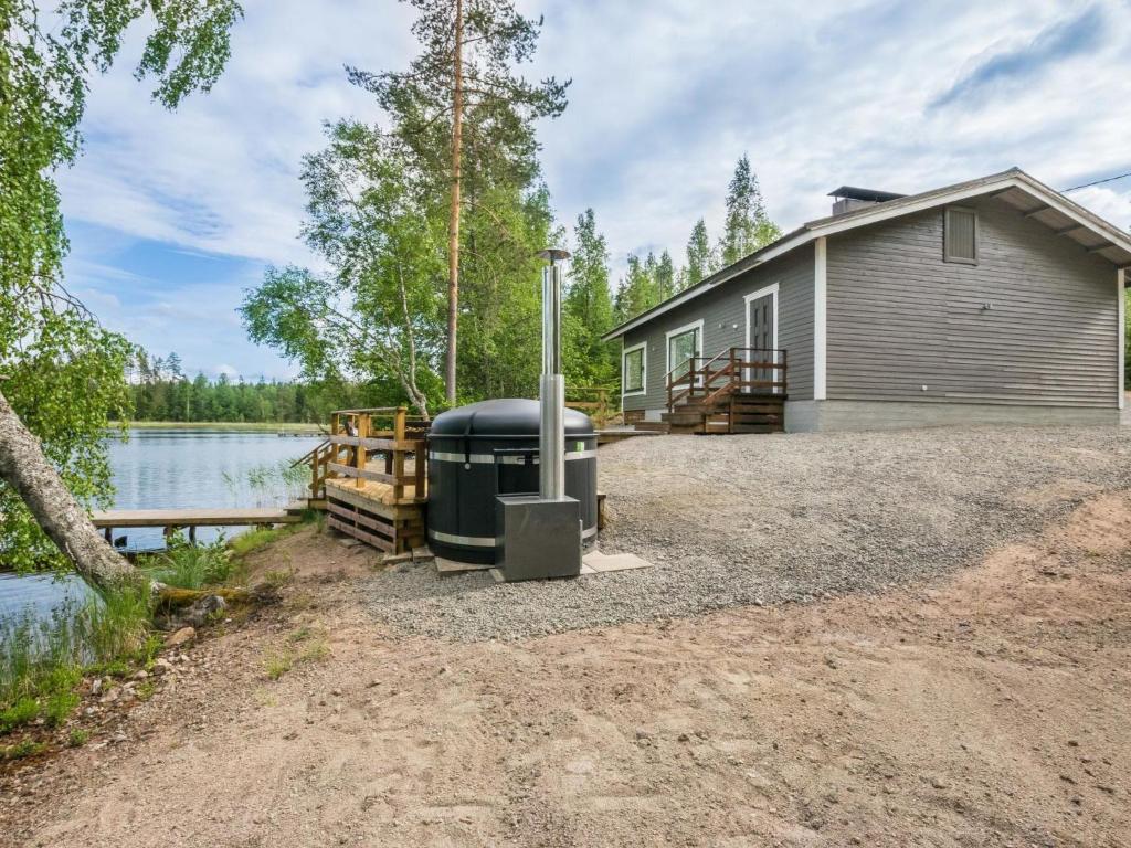 a house with a jet ski parked next to a lake at Holiday Home Tähtiranta by Interhome in Valkeala