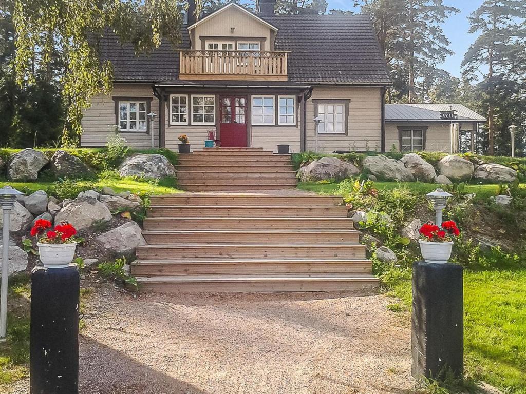 uma casa com uma porta vermelha e escadas à frente em Holiday Home Päätalo by Interhome em Vääksy