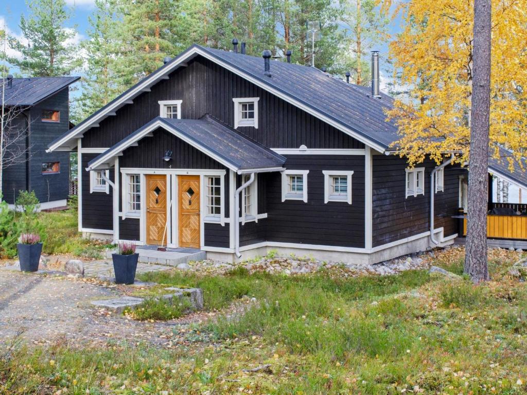 een zwart huis met een gambrel dak bij Holiday Home Koliwood a by Interhome in Kolinkylä