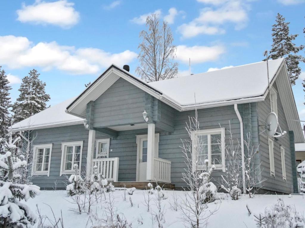 a blue house with snow on the ground at Holiday Home Villa sofia by Interhome in Vuokatti