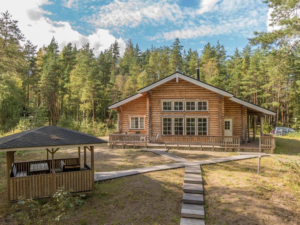 una cabaña de madera en el bosque con cenador en Holiday Home Valkealammi by Interhome, en Vehmainen