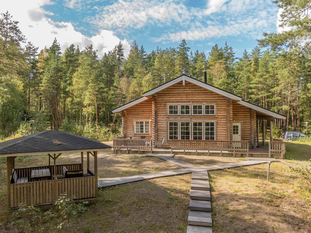 Una cabaña de troncos en el bosque con un cenador en Holiday Home Valkealammi by Interhome, en Vehmainen