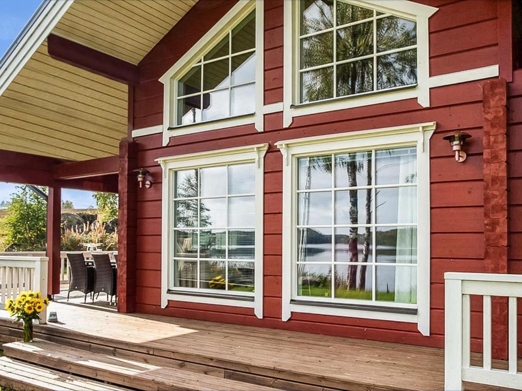 une maison rouge avec des fenêtres blanches et une terrasse dans l'établissement Holiday Home Myllymökki by Interhome, à Hara