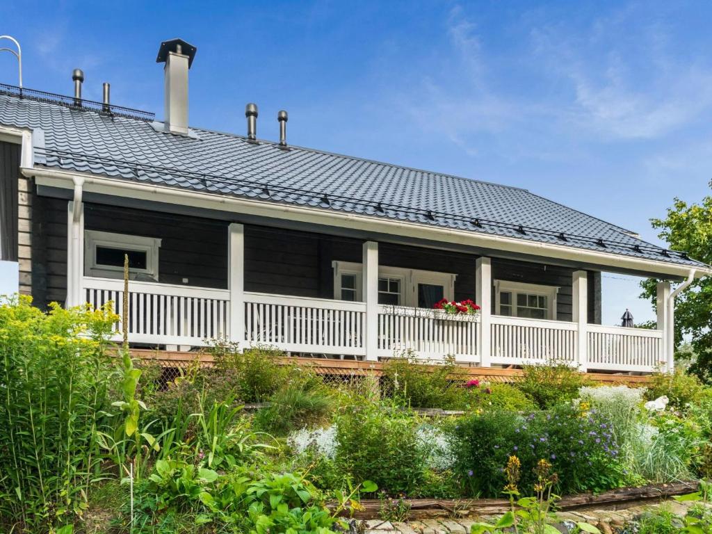 a house with a white porch and a roof at Holiday Home Suviranta by Interhome in Suonenjoki