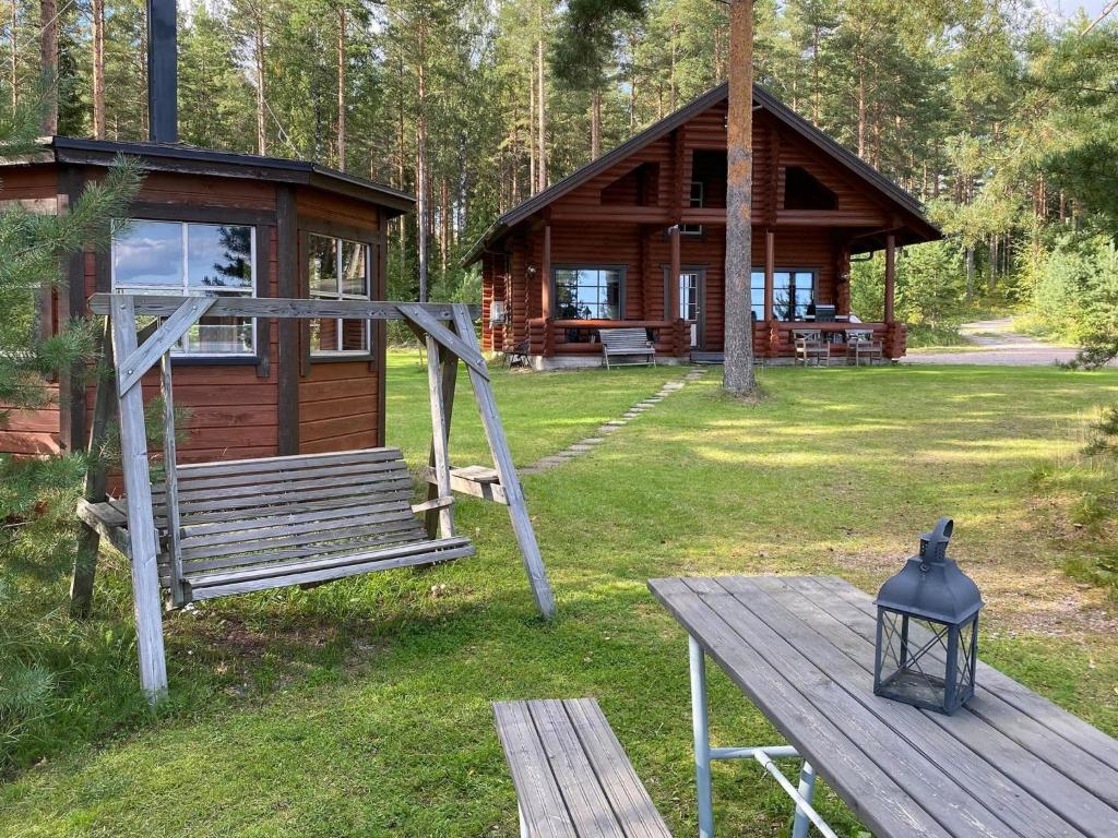 een houten hut met een bank en een tafel bij Holiday Home Raatiannokka by Interhome in Ikaalinen