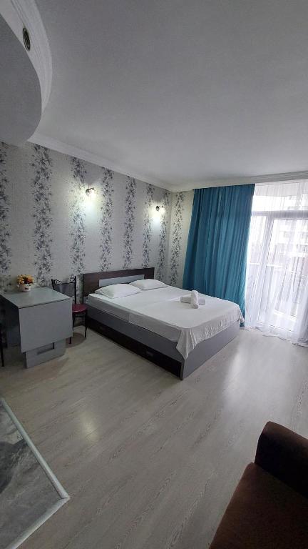 Un dormitorio con una gran cama blanca y una ventana en Orbi Sea Towers Batumi, en Batumi