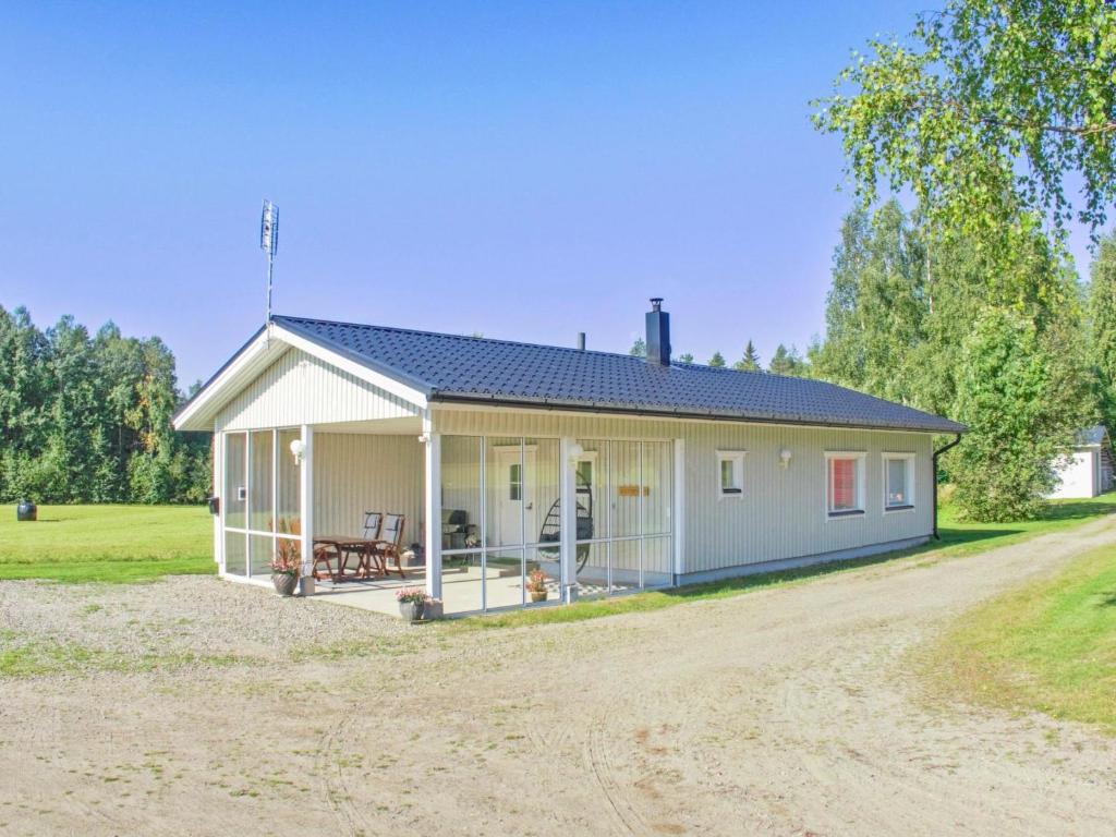 a small white house on a dirt road at Holiday Home Metsätähti by Interhome in Vuokatti