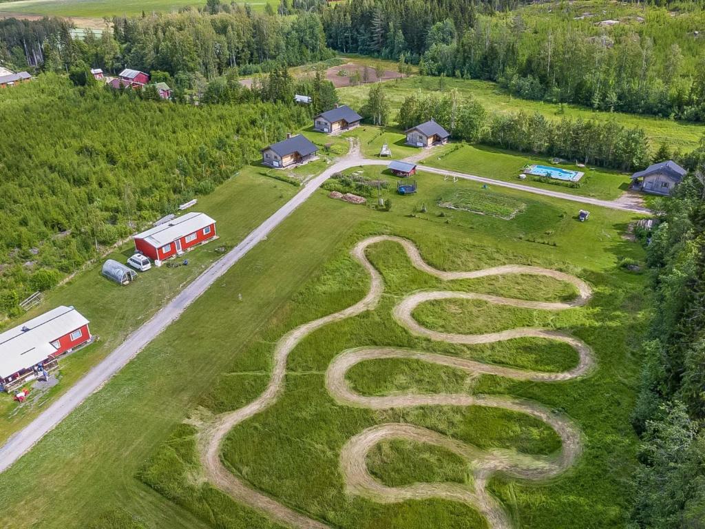 una vista aérea de una granja con una serpiente pintada en la hierba en Holiday Home Luisku by Interhome en Punkalaidun
