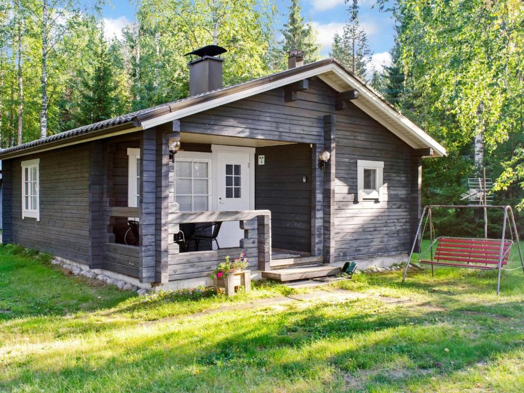 ein kleines Haus mit einer Bank im Hof in der Unterkunft Holiday Home Maunonlahti by Interhome in Hattusaari