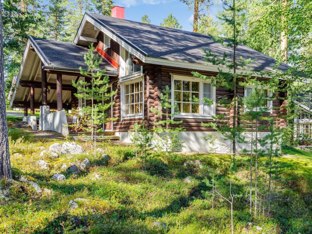 eine Blockhütte im Wald mit einem Hof in der Unterkunft Holiday Home Honkakoli 10 by Interhome in Hattusaari