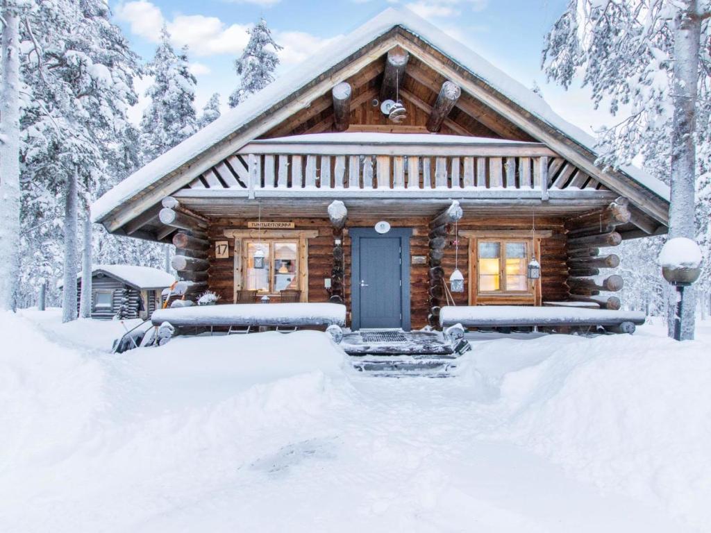 a log cabin with a blue door in the snow at Holiday Home Tunturitorppa by Interhome in Äkäslompolo