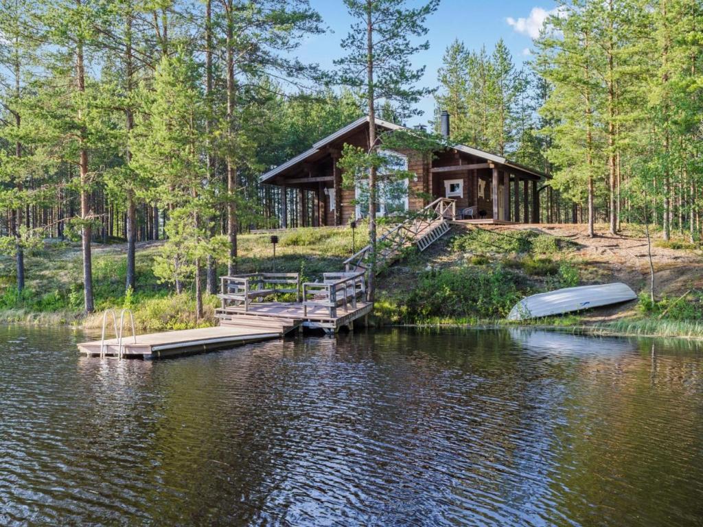 a cabin on a lake with a dock and a boat at Holiday Home Papulantupa by Interhome in Kulho