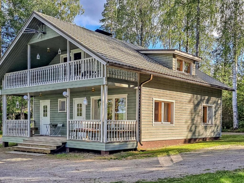 a small house with a porch and a balcony at Holiday Home Kesäranta by Interhome in Simanala