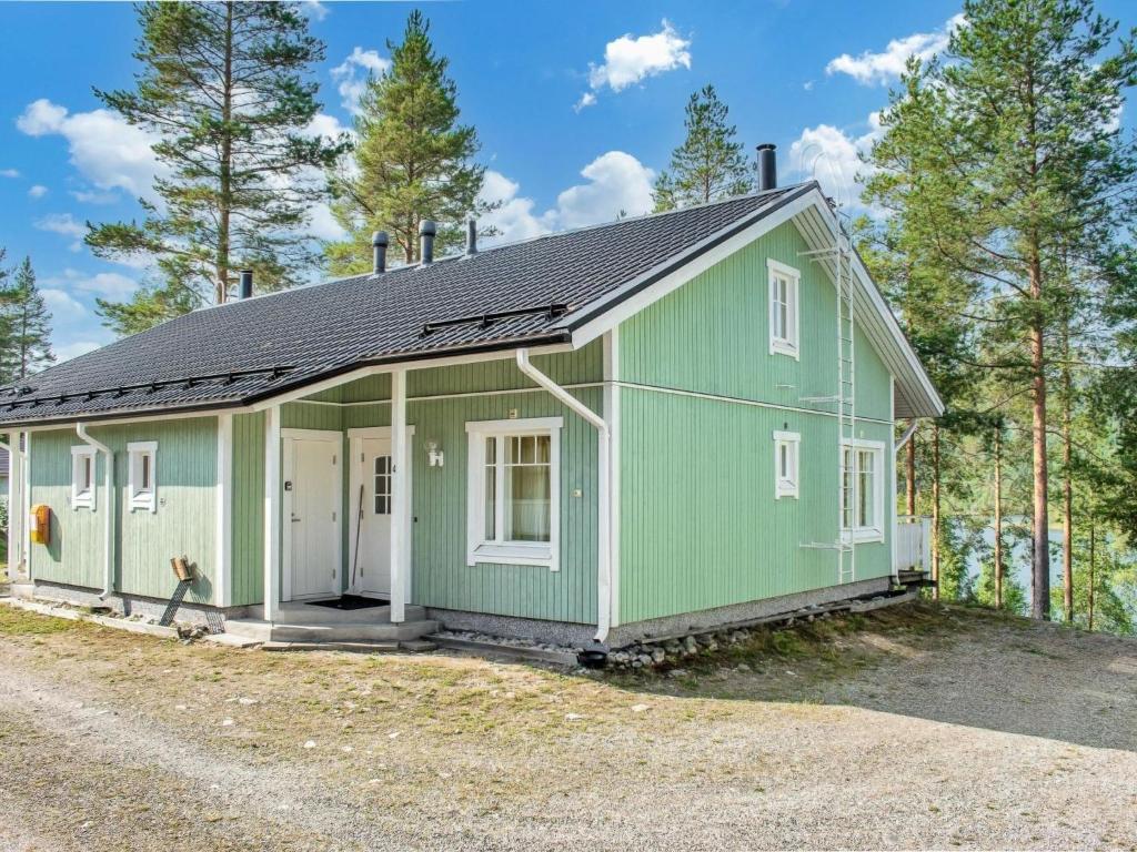 ein grünes Haus mit schwarzem Dach in der Unterkunft Holiday Home Saunaharju 4 by Interhome in Kolinkylä