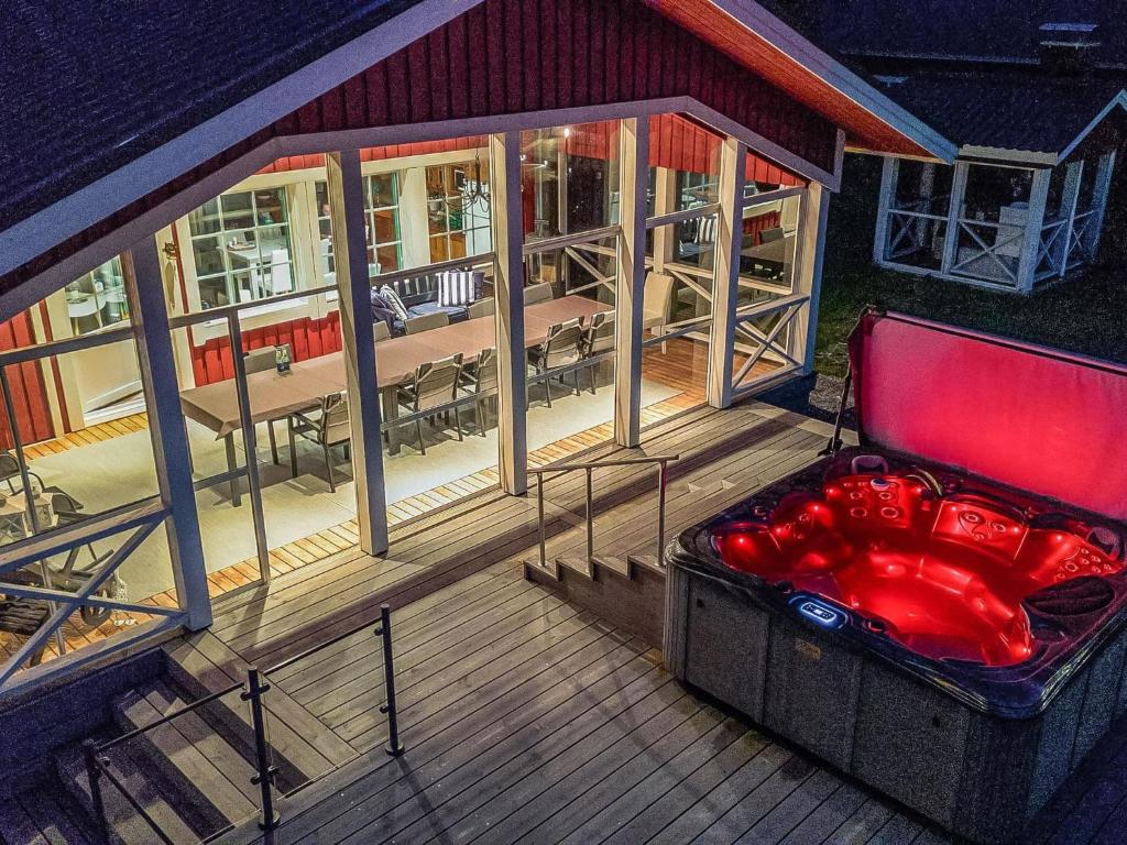 une terrasse ouverte avec un banc rouge sur une maison dans l'établissement Holiday Home Villa blomvik by Interhome, à Kristenäs