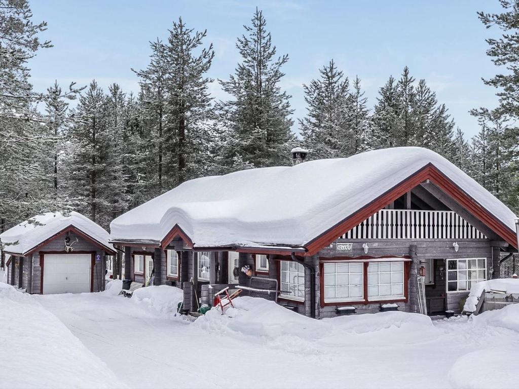 ルオストにあるHoliday Home Kerkkälä by Interhomeの屋根に雪が積もった丸太キャビン