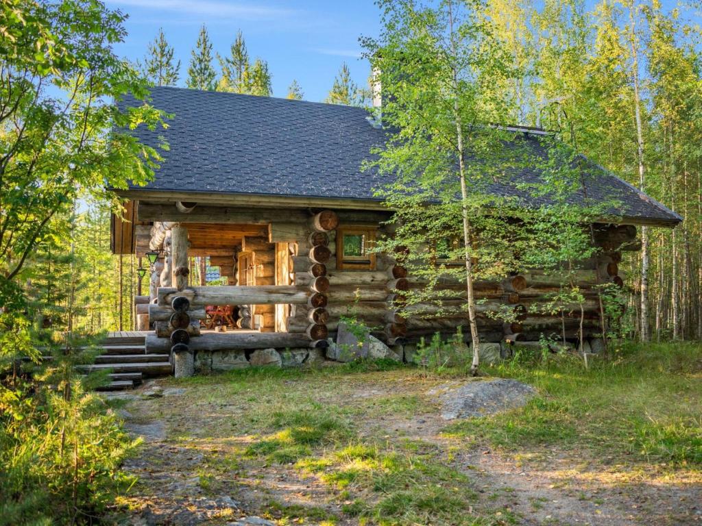une cabane en rondins dans les bois avec un chemin devant dans l'établissement Holiday Home Köllölä 1 by Interhome, à Nunnanlahti