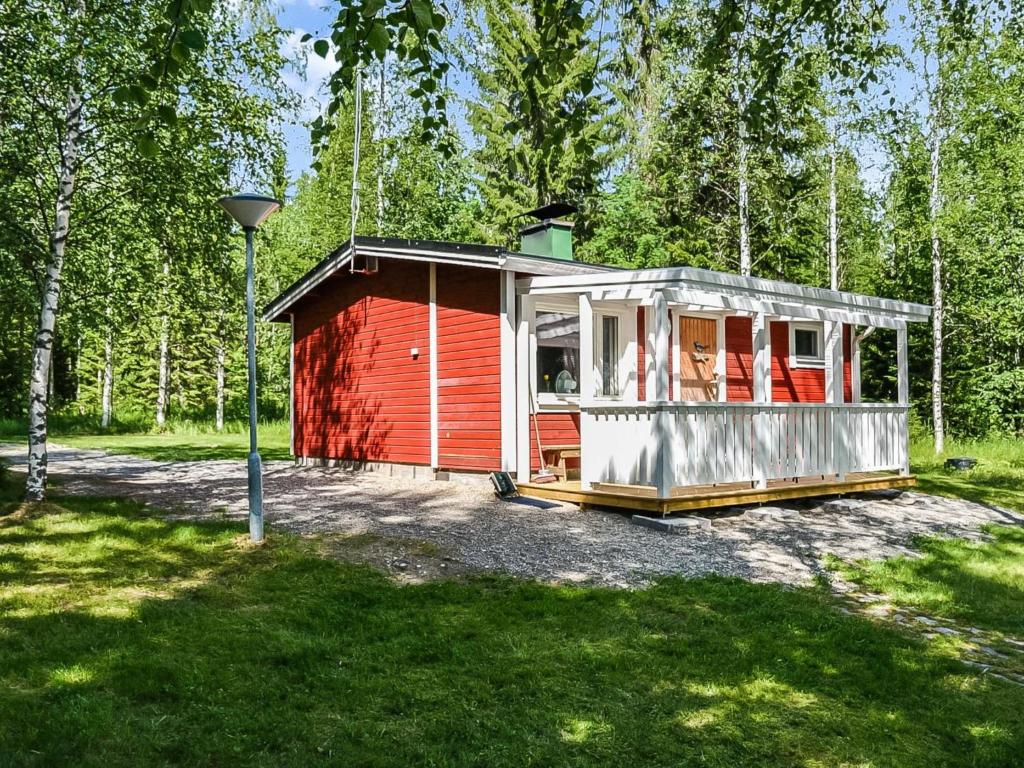 czerwony dom w środku lasu w obiekcie Holiday Home Västäräkki by Interhome w mieście Urimolahti