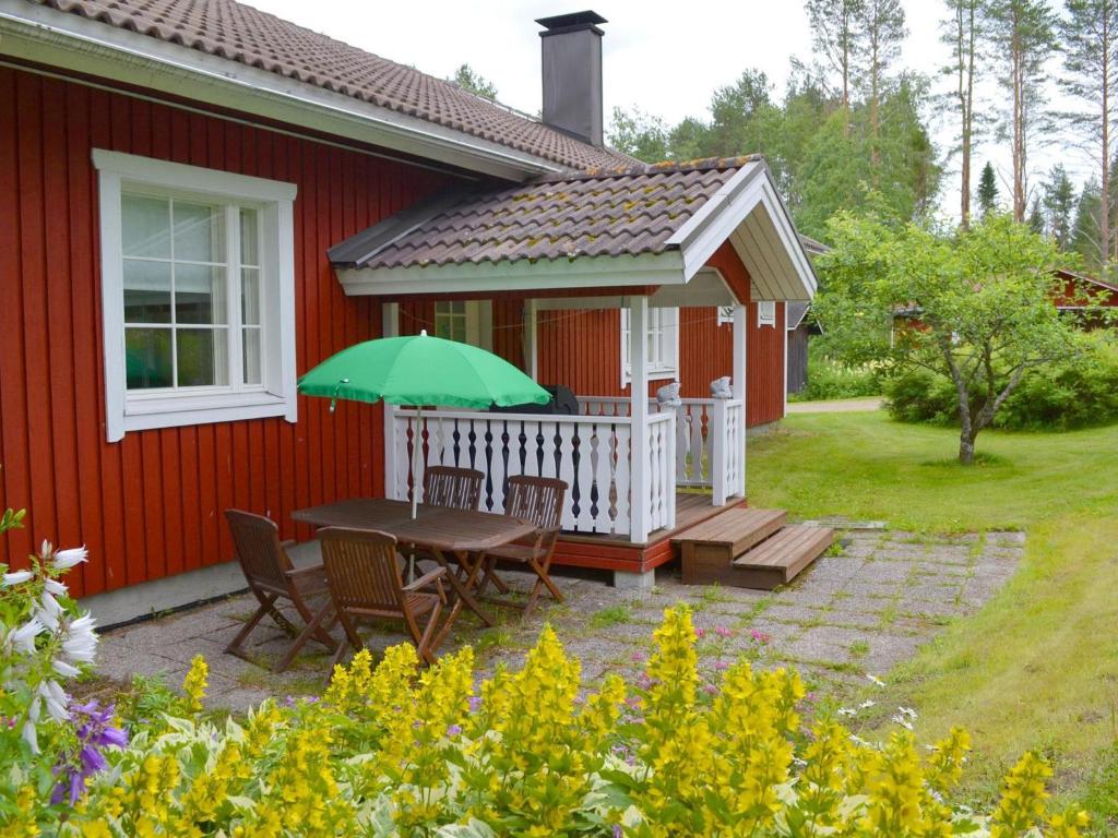 d'une terrasse avec une table et un parasol vert. dans l'établissement Holiday Home Ranta-heikkilä by Interhome, à Pyhälahti