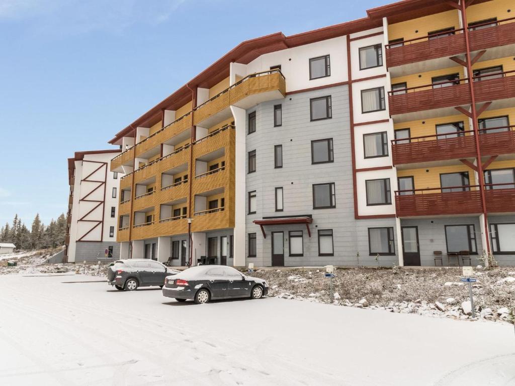 two cars parked in a parking lot in front of a building at Holiday Home Ylläs chalets 2301 by Interhome in Ylläsjärvi