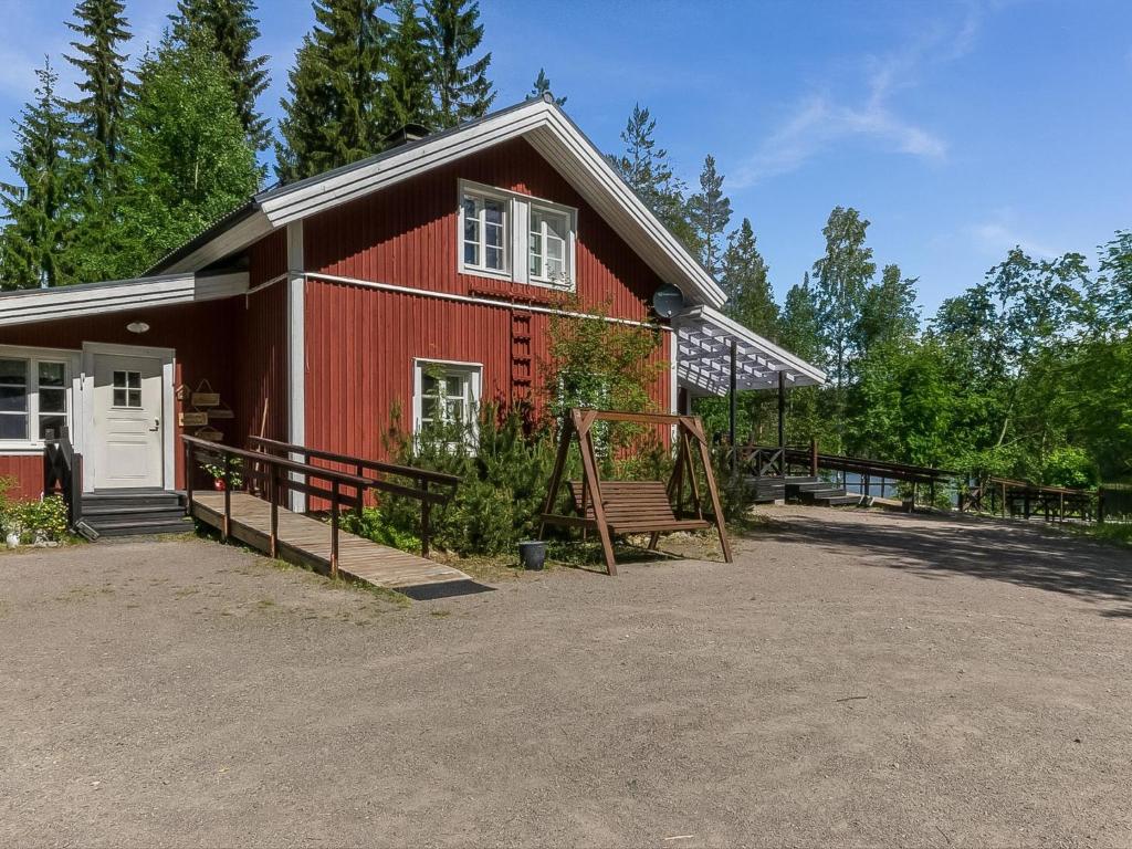 un granero rojo con un banco delante de él en Holiday Home Myllytupa by Interhome, en Tihusniemi