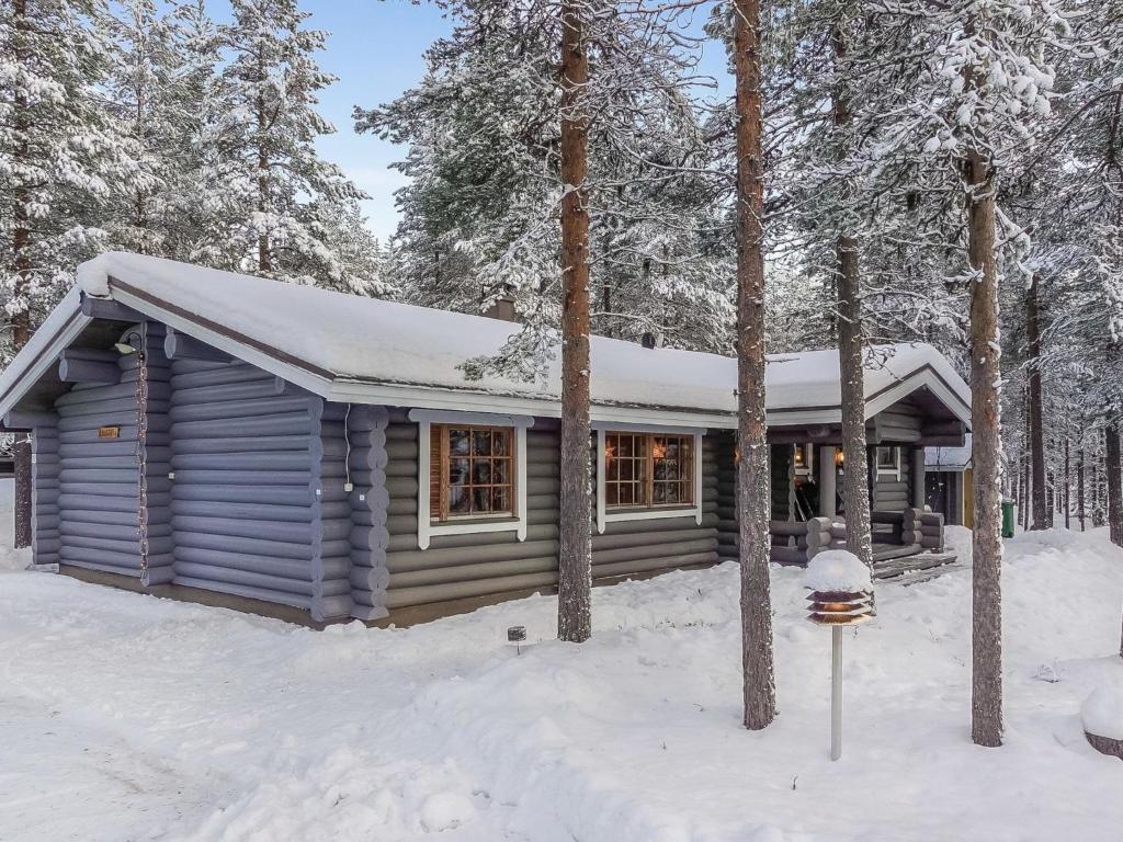 a cabin in the woods with snow on the ground at Holiday Home Pasyni by Interhome in Sirkka