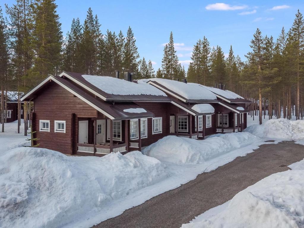 a log cabin in the snow with snow piled up at Holiday Home Levin kultakoto by Interhome in Sirkka