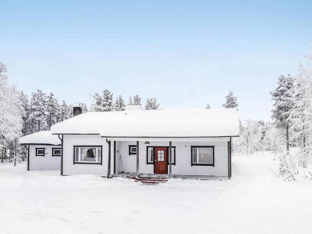 una pequeña casa blanca con techo cubierto de nieve en Holiday Home Tieva by Interhome, en Peltovuoma