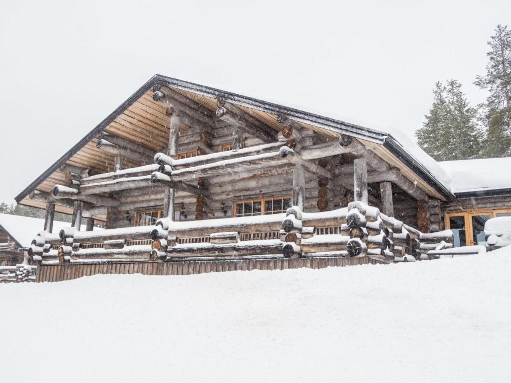 a log cabin is covered in snow at Holiday Home Voimapolku 4 a by Interhome in Ruka