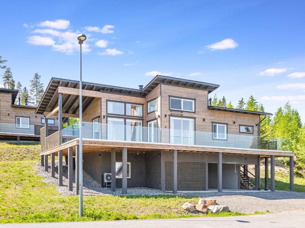 a large house with a deck on a hill at Holiday Home Viherlaakso a by Interhome in Tahkovuori