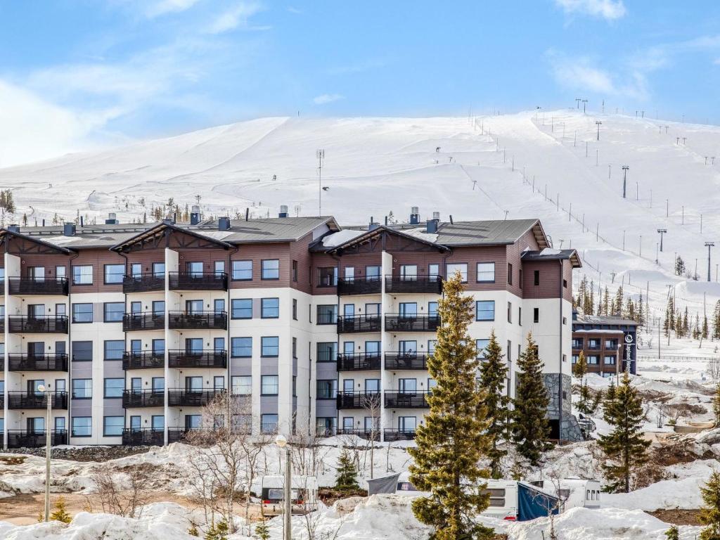 un edificio nella neve con una montagna sullo sfondo di Holiday Home Nordic chalet 9102 by Interhome a Ylläsjärvi