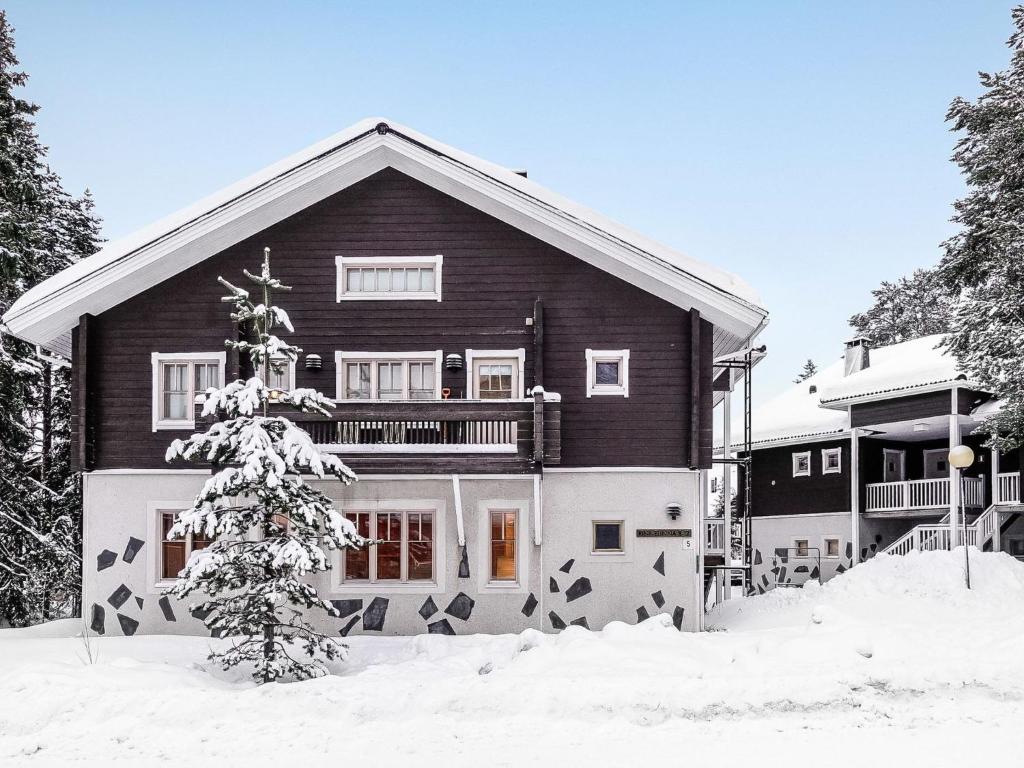 ein großes Holzhaus im Schnee mit einem Weihnachtsbaum in der Unterkunft Holiday Home Levin rinnelinna a8 by Interhome in Sirkka