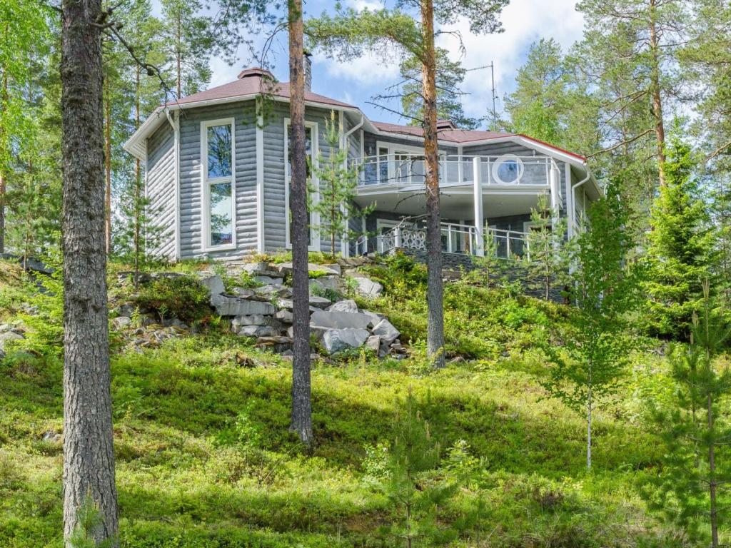 ein Haus auf einem Hügel im Wald in der Unterkunft Holiday Home Huvila lomaonni by Interhome in Kolinkylä