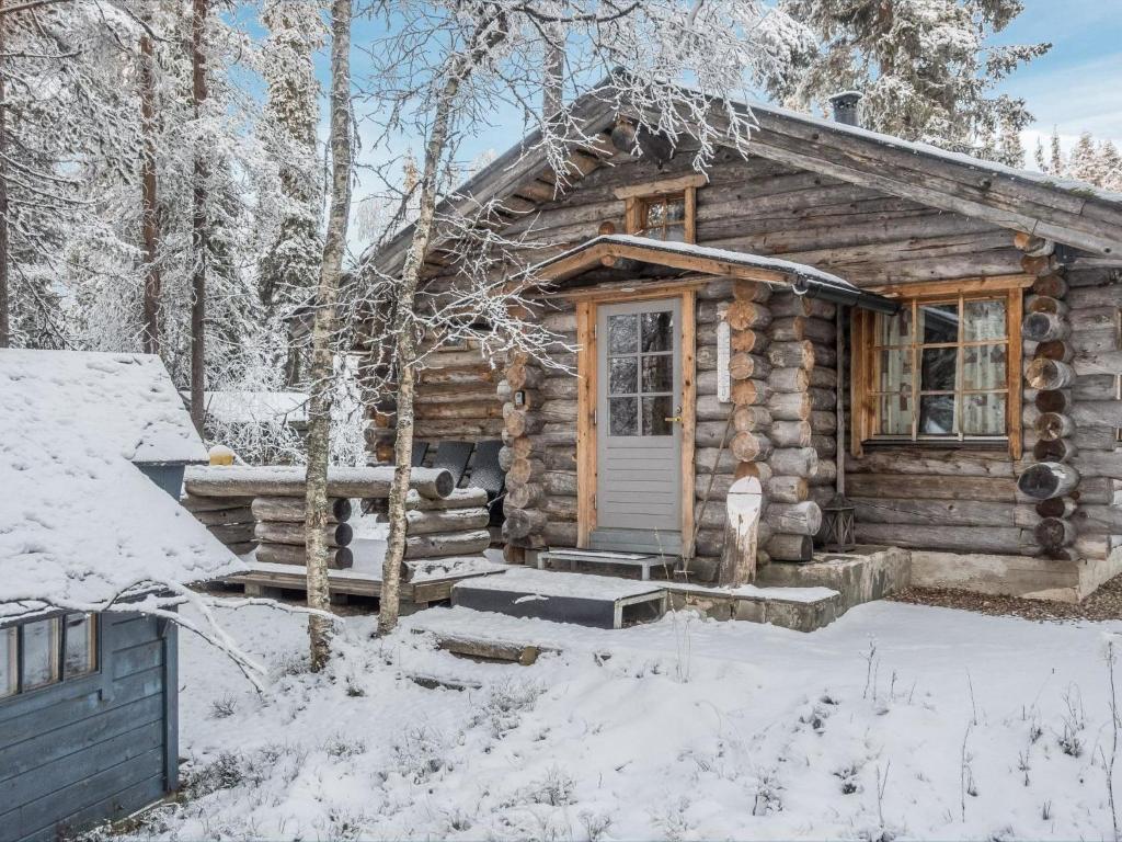 uma cabana de madeira na floresta na neve em Holiday Home Kelokota by Interhome em Salla