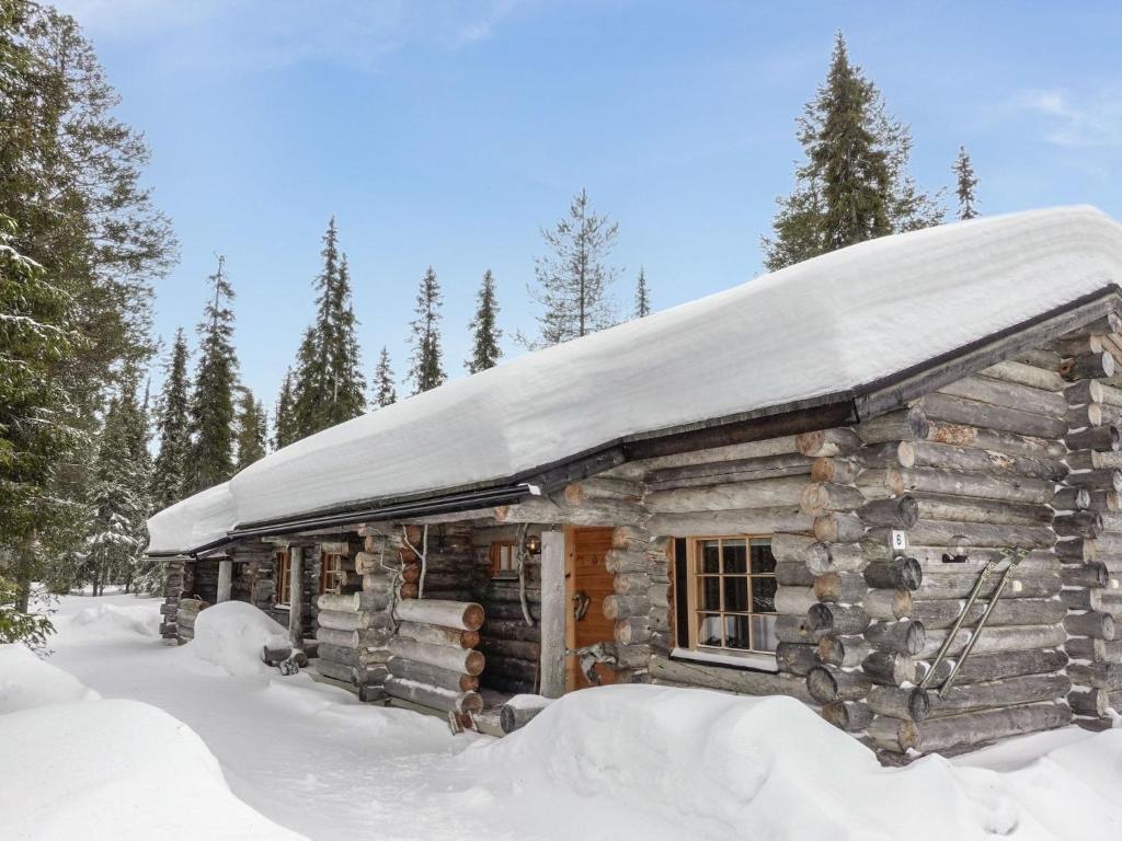 a log cabin with a snow covered roof at Holiday Home Aihkelo by Interhome in Luosto