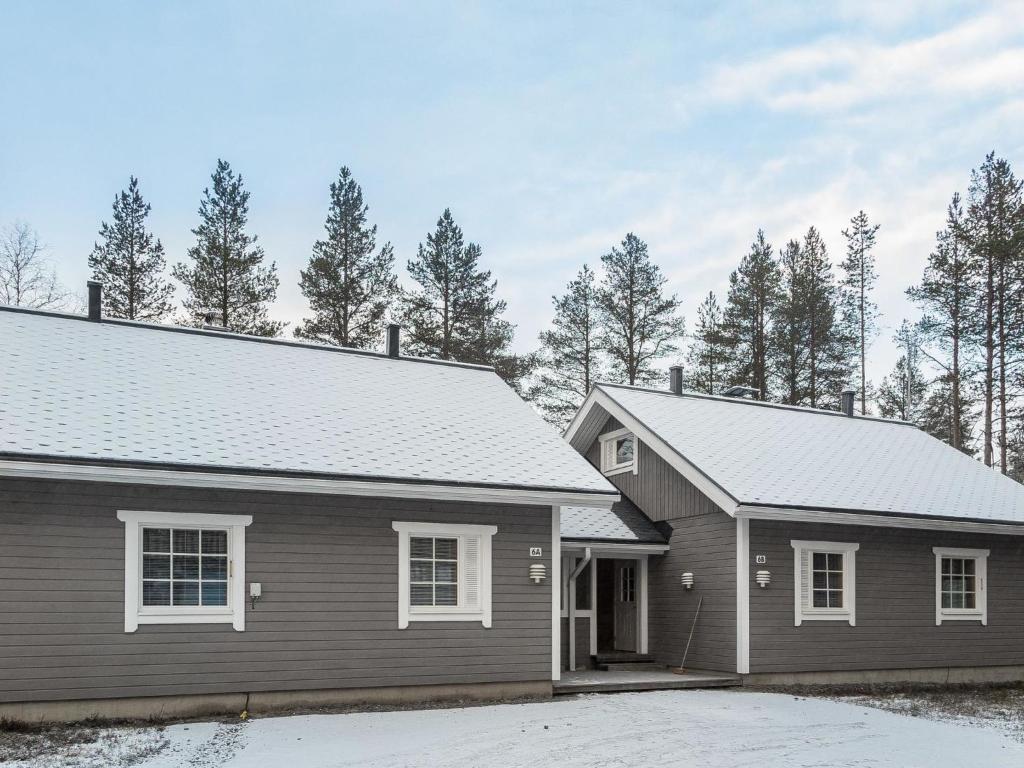 a home with a gray house and trees at Holiday Home Lapinkulta b by Interhome in Äkäslompolo